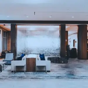 Hotel lobby carpet featuring a large, elegant water feature surrounded by modern seating and decorative plants in dubai