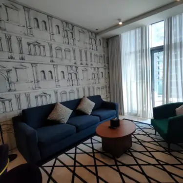 Modern living room with artistic wallpaper and elegant curtains designed by Interior Decoration Company in Dubai